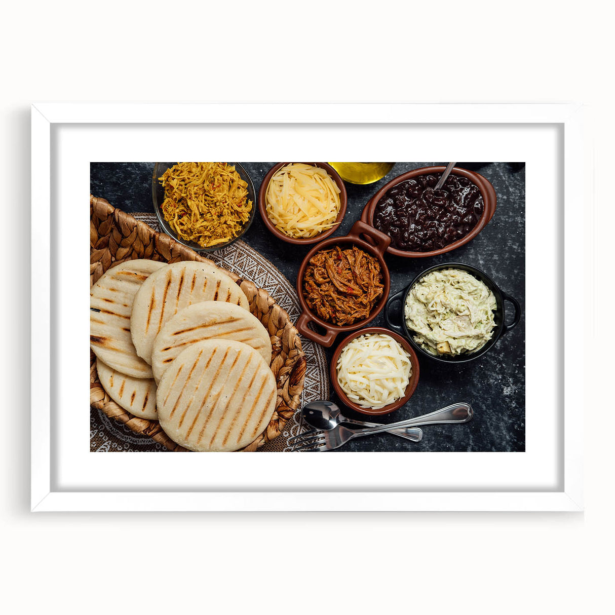 Abstract art print depicting a colorful Venezuelan landscape on a framed white mat, suitable for dining room decor.