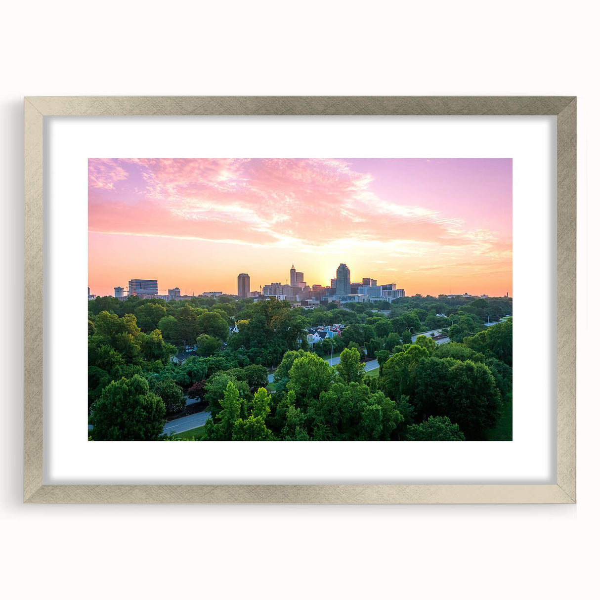 Textured art depicting abstract Raleigh skyline in muted gray and blue tones on a framed silver mat.