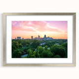 Textured art depicting abstract Raleigh skyline in muted gray and blue tones on a framed silver mat.