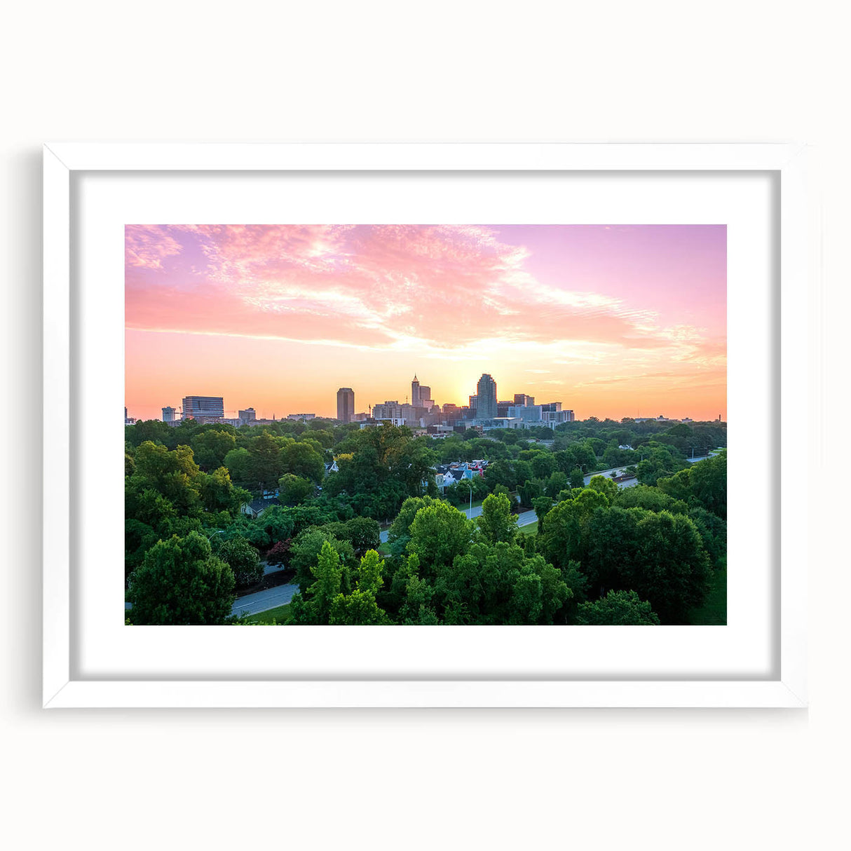 Abstract art print of Raleigh skyline in muted blue and gray tones on a framed white mat, ideal for dining room decor.
