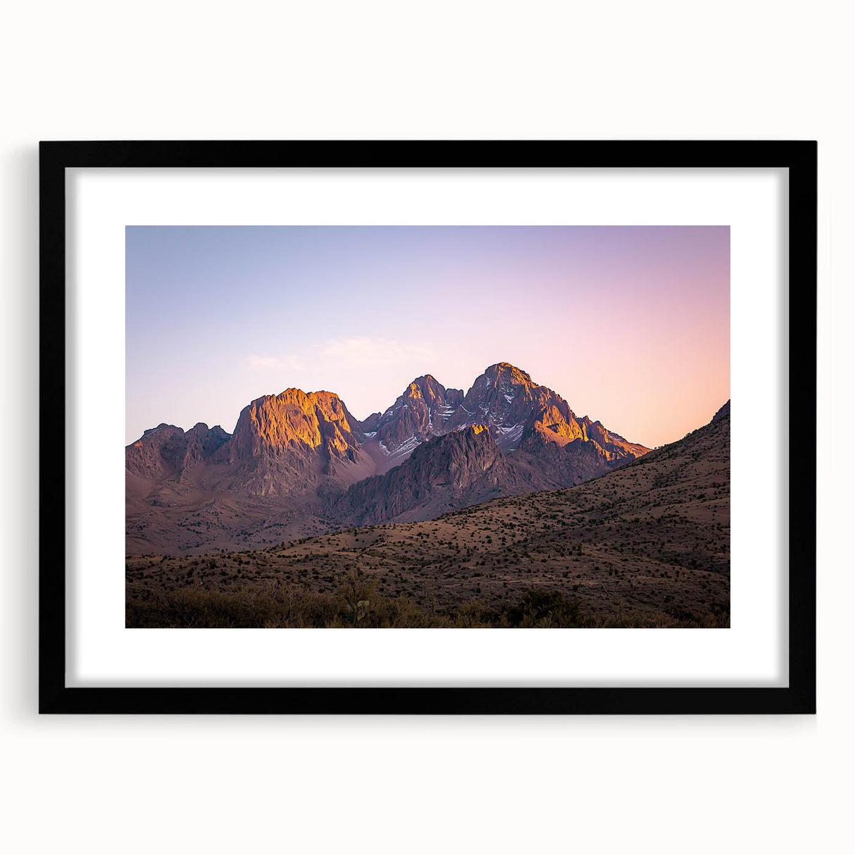 Black-framed landscape artwork showcasing dramatic cliffs and serene natural scenery, featuring a white mat for an elegant presentation in home decor.