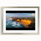 Silver-framed landscape artwork showcasing rugged cliffs and serene skies, elegantly matted for a polished presentation, perfect for home decor enhancement.