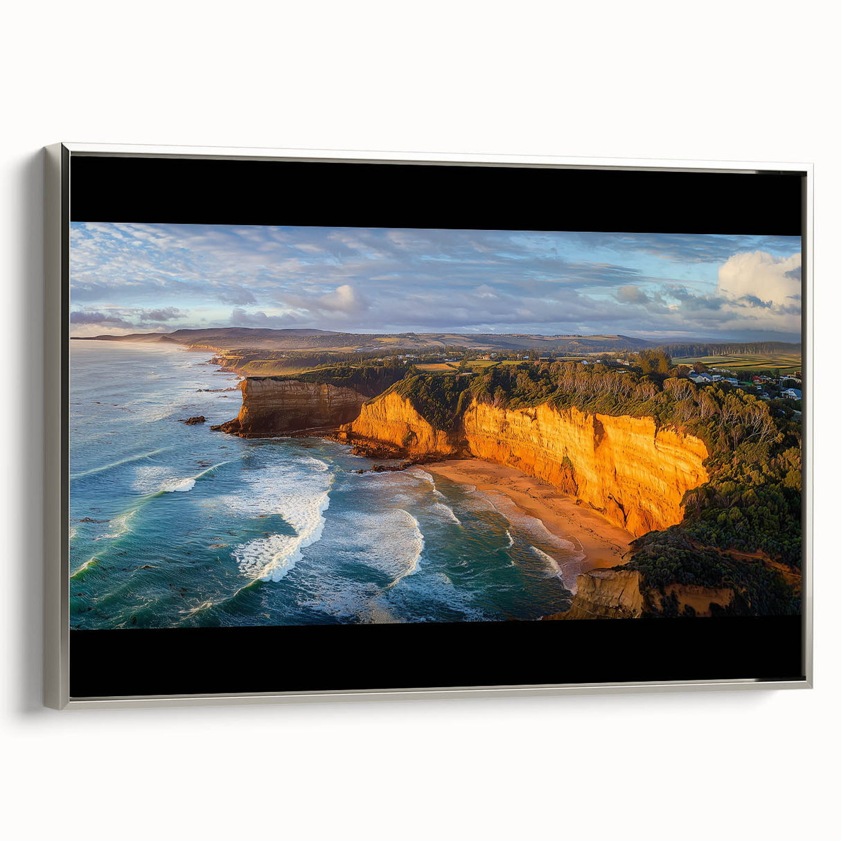 Framed canvas artwork showcasing a stunning landscape of dramatic cliffs, featuring a sleek silver frame and vibrant colors, perfect for modern home decor.