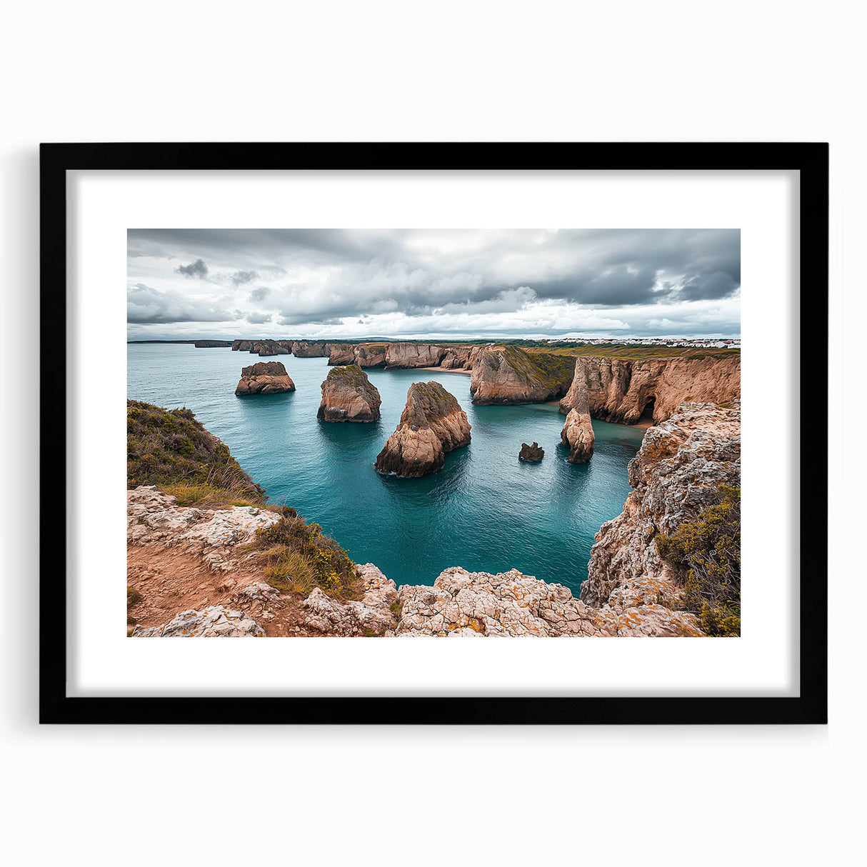 Black-framed landscape artwork depicting dramatic cliffs and ocean waves, elegantly matted for a sophisticated presentation in home decor.