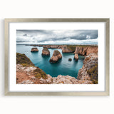 Silver-framed landscape artwork showcasing dramatic cliffs and serene natural beauty, elegantly matted for an upscale presentation, ideal for home decor.