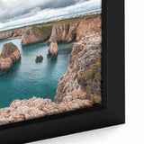 Close-up of a framed canvas artwork depicting a dramatic cliff landscape with vibrant colors and intricate details, perfect for enhancing home decor.