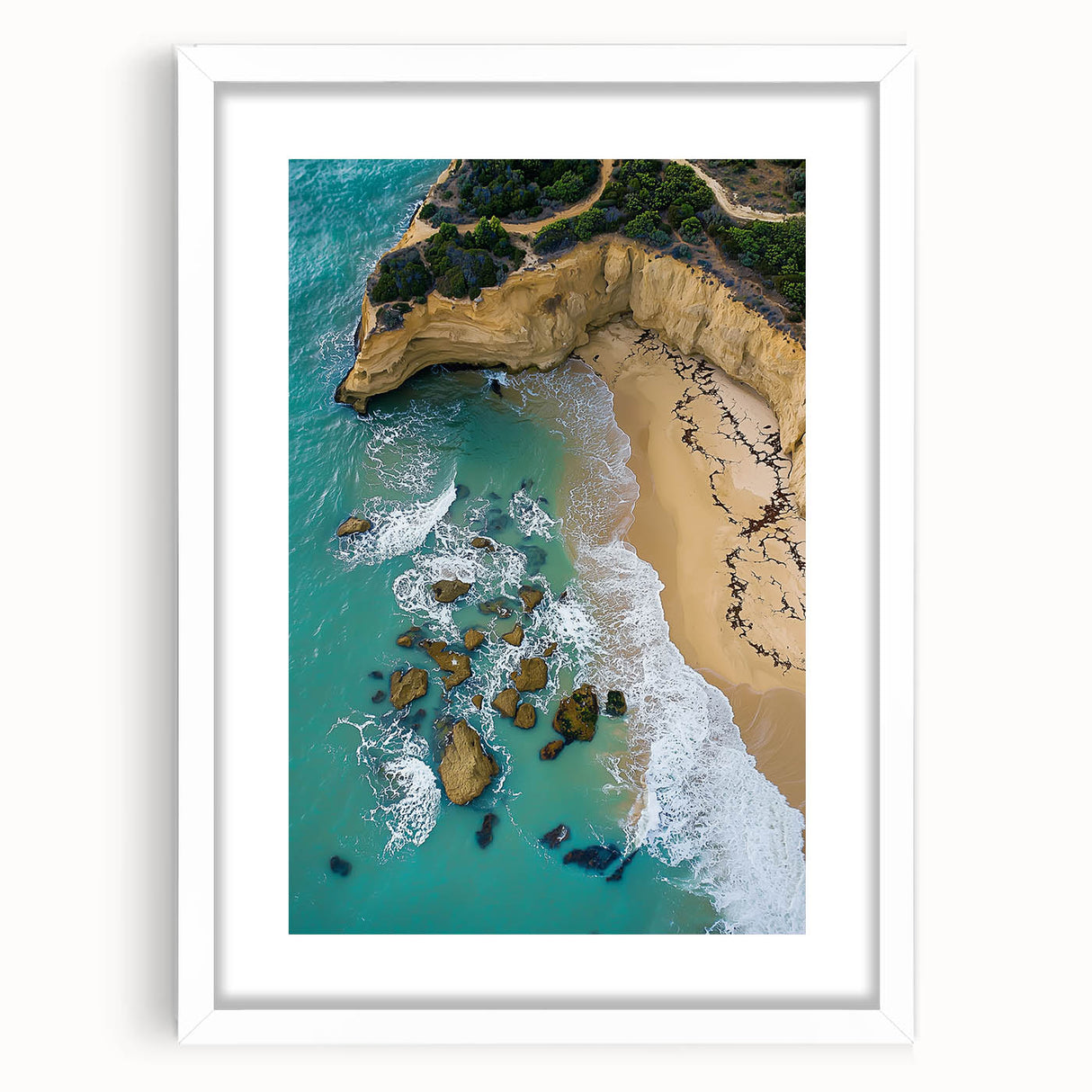 Framed landscape artwork featuring dramatic cliffs and a serene ocean view, elegantly matted in white, perfect for enhancing modern home decor.