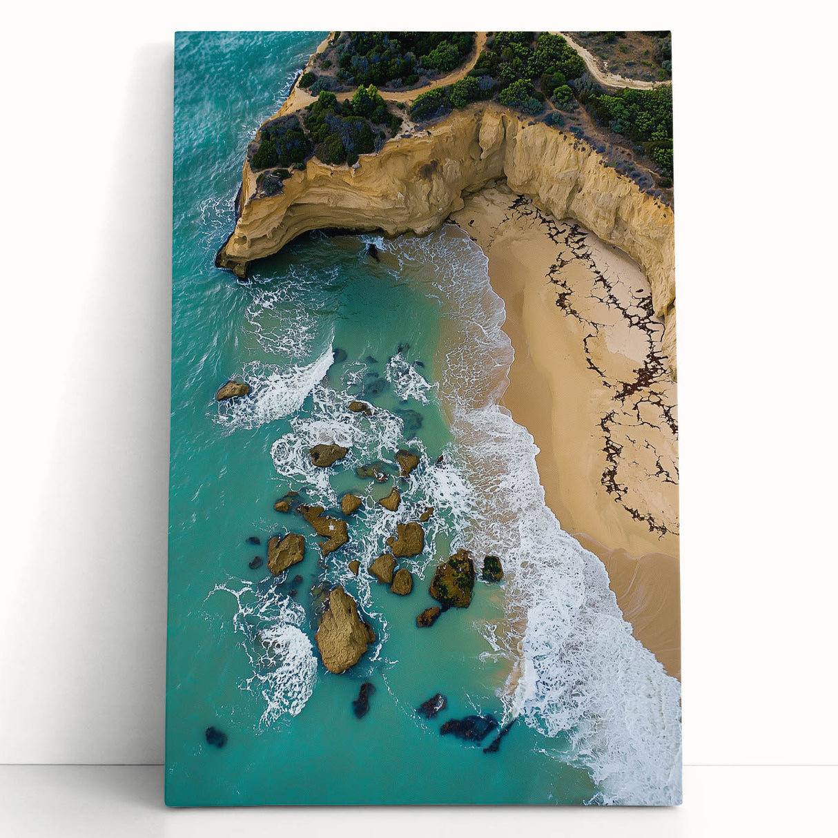 Stretched canvas artwork depicting vibrant cliff landscapes in rich earthy tones, leaning against a neutral wall, perfect for modern home decor.