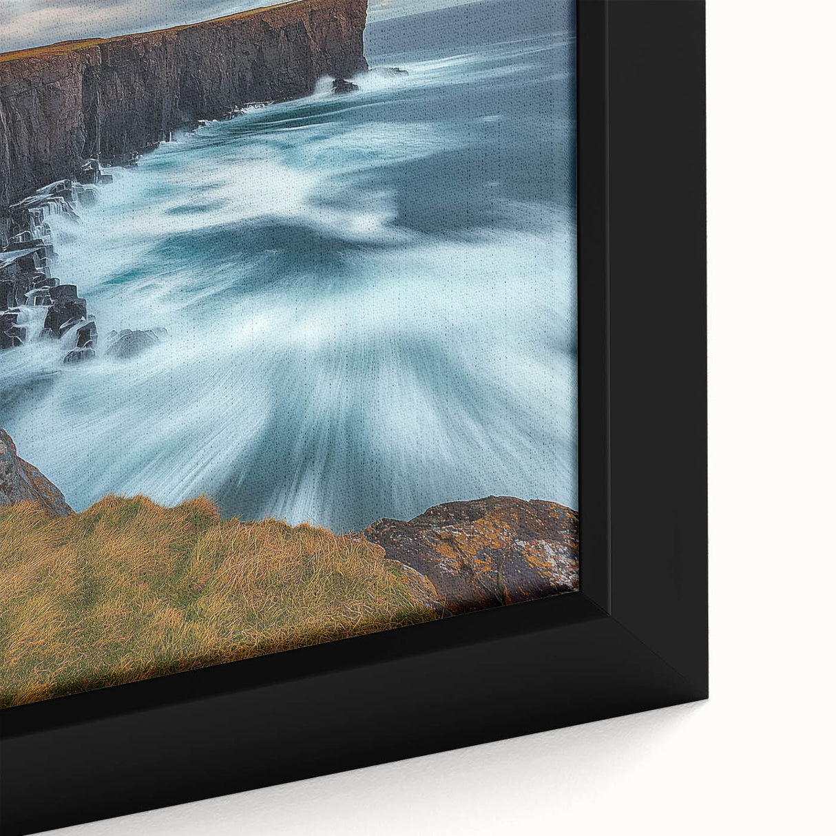 Close-up of a framed canvas depicting a stunning landscape of rugged cliffs and vibrant greenery, showcasing intricate textures and rich colors, perfect for home decor.