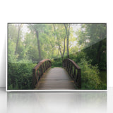 Framed acrylic artwork depicting a tranquil landscape bridge scene in soft hues of blue and green, ideal for enhancing modern home decor or office spaces. This piece adds a serene touch to any room with its elegant framing and vibrant colors.