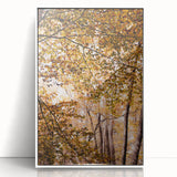 Art deco poster of autumnal trees in muted orange and brown hues, acrylic print in white frame.