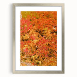Textured abstract art print in warm autumn hues on a silver-framed canvas, ideal for bedroom wall decor.