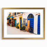 Textured abstract art print of a Moroccan landscape in muted earth tones, framed in gold, suitable for bedroom decor.