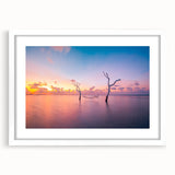 Abstract art print of Maldivian scenery in muted blue and green tones on a framed white mat, ideal for dining room decor.