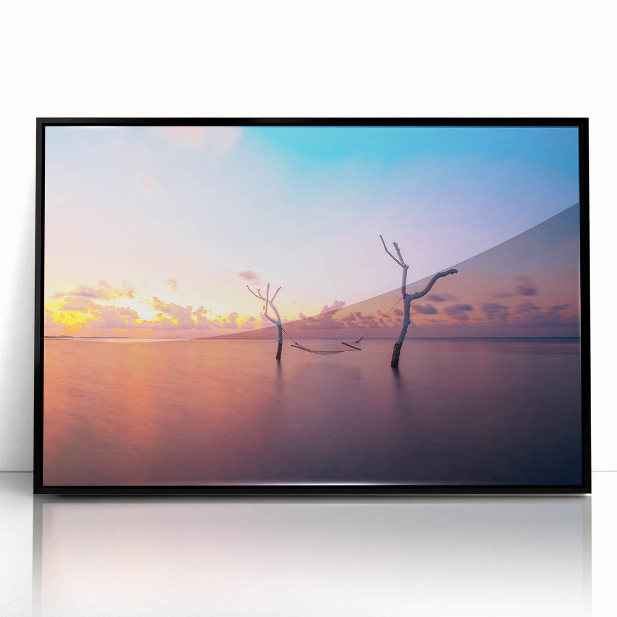 Large abstract wall art depicting a serene Maldivian scenery in muted blue and green tones, framed in black acrylic.