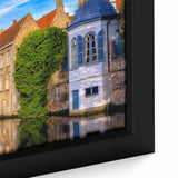 Close-up of textured black wall art featuring a colorful European scenery on framed canvas, ideal for living room decor.