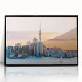 Large abstract wall art depicting Auckland's skyline in muted gray and blue tones, framed in black acrylic.