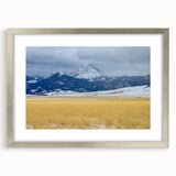 Textured art print of abstract Montana landscape in muted earth tones, framed in silver, ideal for bedroom decor.