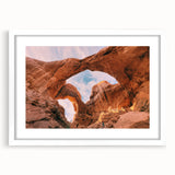 Abstract art print of Arches National Park in muted earth tones, framed in white, suitable for dining room decor.