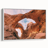 Vintage poster art of Utah's Arches on a framed canvas with a white border, in earthy and blue tones.