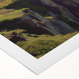 Rolled canvas artwork depicting a stunning landscape of cliffs under a vibrant sunset, showcasing rich colors and intricate details, perfect for home decor.