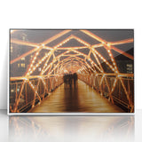 Framed acrylic artwork showcasing a serene landscape view of a bridge surrounded by lush greenery, presented in a sleek white frame, perfect for modern decor.