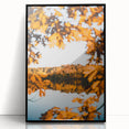 Large abstract wall art depicting fall foliage in warm orange and red tones, framed in black acrylic.