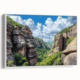 Framed canvas artwork depicting a breathtaking landscape of rugged cliffs under a blue sky, showcasing vibrant colors and intricate details. Perfect for home decor.