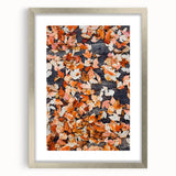 Textured abstract art print in warm autumnal colors on a silver-framed canvas, suitable for bedroom decor.
