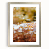 Textured abstract art print in warm autumn hues on a silver-framed canvas, ideal for bedroom decor.