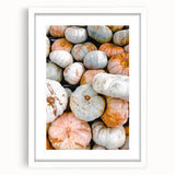 Abstract art print of fall foliage in muted orange and brown tones, framed in white, suitable for dining room decor.