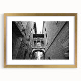Abstract art print of Barcelona scenery in muted gold and blue tones, framed with a gold mat.