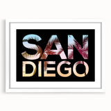 Abstract art print of San Diego skyline in muted blue and gray tones, framed in white, ideal for dining room decor.