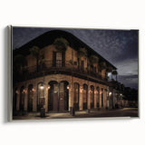 Landscape art painting of New Orleans with colorful buildings and a black sky, printed on a silver-framed canvas.