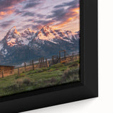 Black wall art featuring a textured depiction of the Grand Tetons under a colorful sky on a framed canvas.