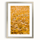 Textured abstract art print in warm autumn hues on a silver-framed canvas, ideal for bedroom wall decor.