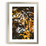 Textured abstract art print in warm autumn hues on a silver-framed canvas, ideal for bedroom decor.