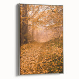 Framed canvas depicting a vintage landscape art painting of autumn trees in vibrant orange and red tones.