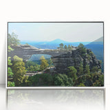 Mid-century modernist art depicting a European cityscape in muted colors on white framed acrylic.