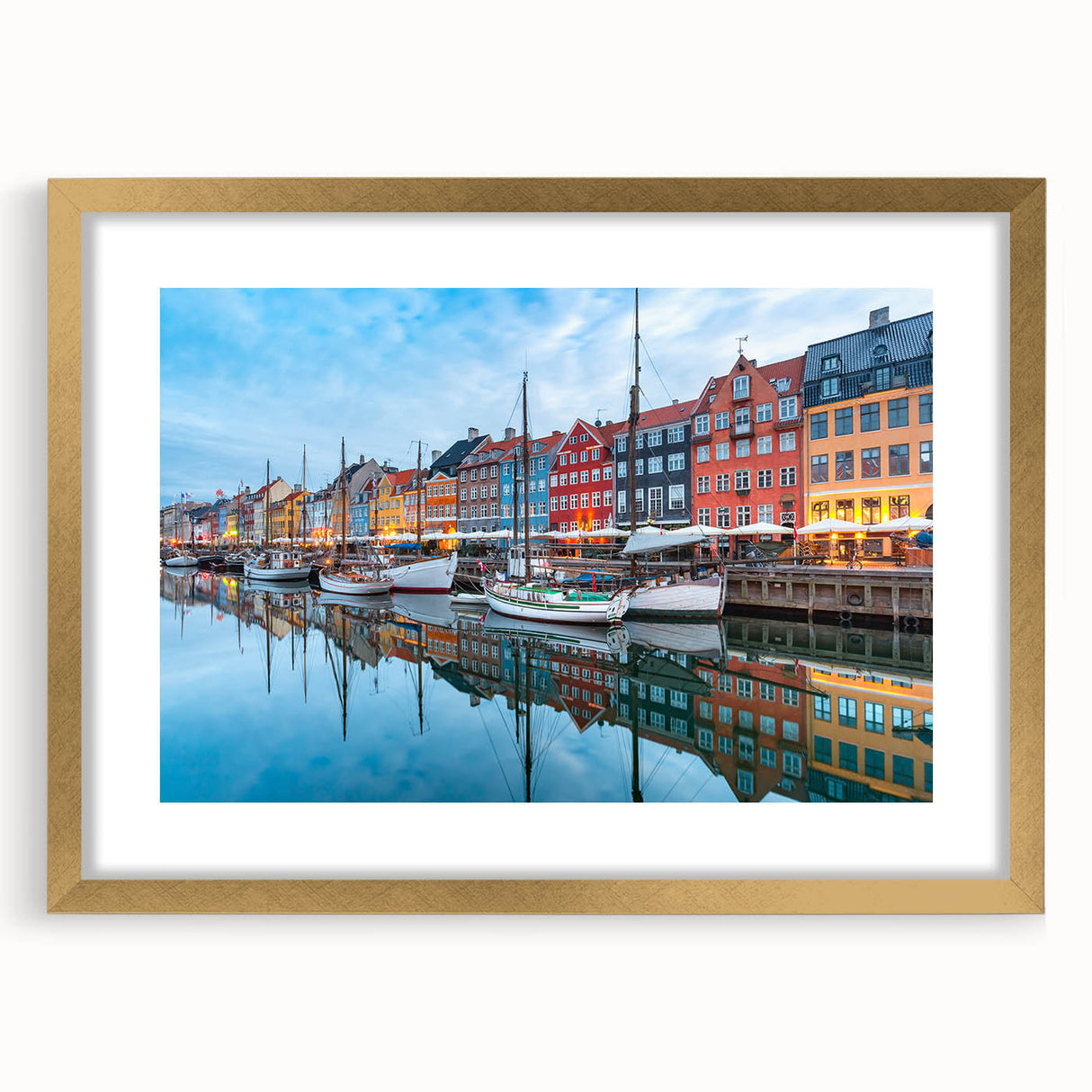 Abstract art print of a European scenery in muted gold and blue tones, framed with a gold mat, ideal for dining room decor.