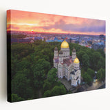 Large art depicting a scenic European landscape in muted green and blue tones on stretched canvas.
