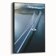 Framed canvas artwork depicting a serene landscape bridge scene, showcasing lush greenery and a tranquil waterway, set against a black frame, ideal for home decor.