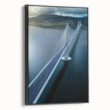 Framed canvas artwork depicting a serene landscape bridge scene, showcasing lush greenery and a tranquil waterway, set against a black frame, ideal for home decor.