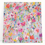 Abstract floral wall art on stretched canvas, featuring vibrant colors of pink, blue, and yellow, leaning against a neutral wall, perfect for modern home decor.