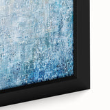 Close-up of an abstract splatter design on a framed canvas, featuring vibrant colors like blue, orange, and yellow, perfect for modern home decor.