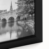 Close-up of a black wall art piece depicting a European scenery in textured colors on a framed canvas.