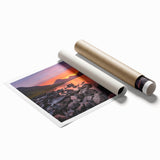 Rolled print of Cumbria landscape with lush green fields and distant hills, in soft earth tones.