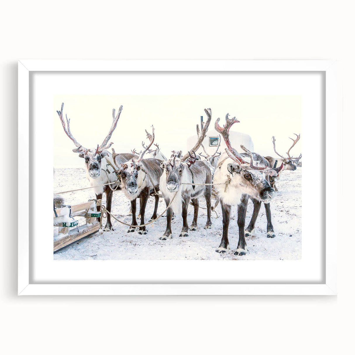 Abstract art print depicting a winter scene in muted blue and white tones on a framed white canvas.