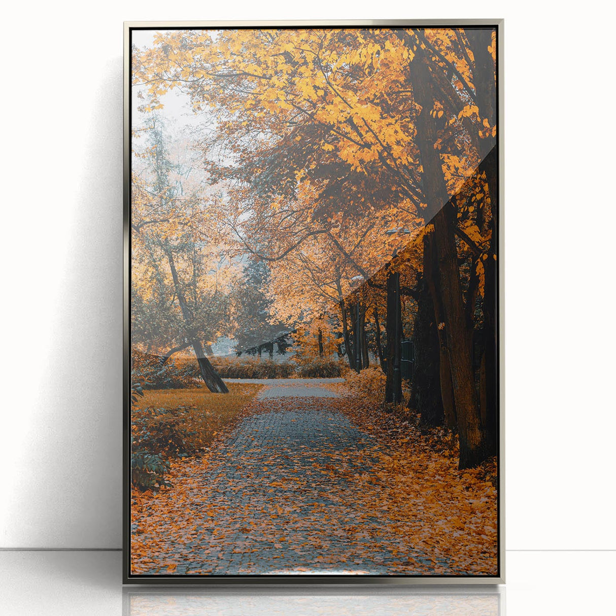 Mid-century modernist art depicting autumn trees in orange and red hues on a silver framed acrylic.