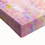 Close-up of an abstract floral stretched canvas artwork showcasing vibrant colors of pink, blue, and green, designed to enhance modern home decor aesthetics.